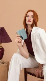 Billetera corta de diseño capitoneado con cierre perimetral y tapa. Cuenta con múltiples compartimentos interiores, tarjeteros y una correa de mano desmontable.