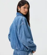 Campera de jean azul estilo balloon, con cuello tradicional, cierre frontal oculto y bajo con elástico.