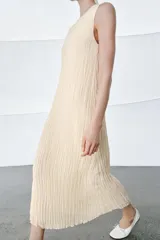 Vestido midi de viscosa con efecto arrugado, cuello redondo y diseño sin mangas. Presenta una sobrecapa superior con bordados detallados y entredoses, con cordones laterales ajustables terminados en borlas.