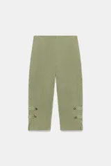 Pantalón capri verde militar de tiro medio, confeccionado en hilatura de algodón con acabado lavado. Presenta cintura elástica y detalles de alamares con botones en los bajos.