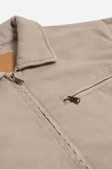 Campera de canvas con diseño utilitario, color negro, con cierre frontal y bolsillo con cierre en el pecho. Presenta cuello camisero y detalles metálicos en los tiradores de los cierres.