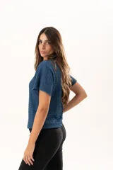 Blusa de silueta relajada y cuello redondo, confeccionada en tela liviana con textura. Presenta mangas cortas y una caída suelta.