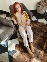 Sweater de punto con diseño geométrico en tonos mostaza, marrón y beige.