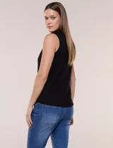 Musculosa de tejido acanalado color negro, con cuello alto y cierre frontal metálico parcial con tirador circular.