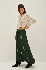 Vestido largo de satén color verde oscuro, con mangas tres cuartos terminadas en volados. Presenta un diseño con bordados dorados detallados en el pecho y cuello, además de motivos florales bordados dispersos a lo largo de la falda. Incluye un cinturón fino con aplicaciones brillantes.