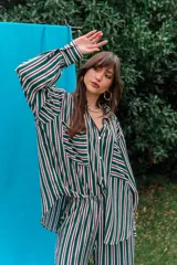Pantalón de fibrana con diseño de rayas verticales en tonos rojos y blancos, de corte amplio y fluido.