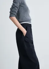 Pantalon de corte recto y tiro medio, confeccionado en tejido técnico de poliéster. Presenta cintura elástica, bolsillos laterales y bolsillos de parche con solapa en las piernas. El bajo cuenta con un sistema de fruncido regulable.