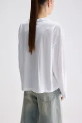 Remera de manga larga color gris verdoso, de calce relajado, con cuello redondo y mangas amplias.