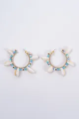 Aros tipo argolla decorados con cuentas de colores fucsia y rosa, intercaladas con pequeñas caracolas naturales y detalles metálicos dorados.