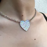 Gargantilla plateada con dije de corazón holográfico.