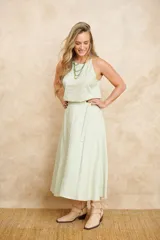 Pollera larga evasé color verde claro, con cintura alta y cinturón de la misma tela.