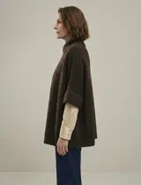 Capa tejida color fucsia, con cuello alto abotonado y mangas cortas estilo japonesa. Tejido de punto grueso.