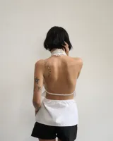 Top blanco de poplin con espalda semi descubierta y tiras regulables.