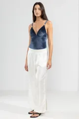 Pantalón de lino italiano color blanco con hilo metalizado, corte recto, talle medio, cintura elástica en la parte trasera y bolsillos delanteros.