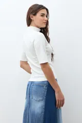 Remera de cuello alto tipo media polera, de manga corta y corte ajustado al cuerpo, en color crudo.