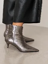 Bota corta de cuero con punta fina y taco fino de 5 cm, diseño minimalista y elegante.