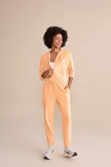Pantalón jogger color durazno de tejido frosty con superficie plush de tacto suave y aterciopelado. Tiene cintura media con ajuste mediante amarre y bolsillos laterales.
