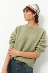 Sweater verde claro tramado de manga larga y cuello redondo.