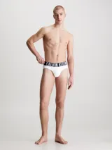 Pack de tres slips para hombre, confeccionados en microfibra de poliéster reciclado y elastano. El slip visible es de color gris liso con cinturilla elástica negra que lleva el logo de Calvin Klein en gris.