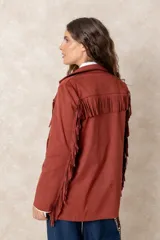 Chaqueta de gamuza color terracota con diseño de flecos en el frente y las mangas. Presenta cuello solapa, cierre frontal y bolsillos delanteros.