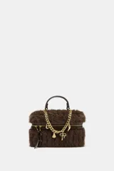 Bolso rígido tipo clutch con acabado de pelo sintético en color marrón. Presenta una cadena decorativa dorada con charms colgantes en la parte frontal, asa de mano superior y cierre de cremallera.