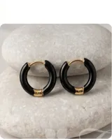 Aros tipo argolla de tamaño pequeño, con diseño minimalista en color negro brillante y detalle metálico en el cierre.