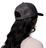Gorro tipo trucker de Columbia, con frente negro y paneles traseros de malla gris. Presenta un parche frontal con diseño de montañas y logo de la marca.