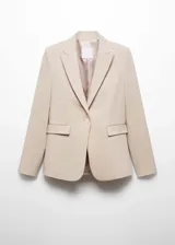 Blazer entallado de color beige con solapas de muesca, hombros estructurados y cierre frontal de un botón. Presenta bolsillos de ribete delanteros, pinzas de entalle y abertura posterior.
