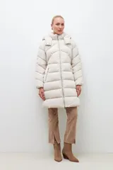 Campera puffer de corte largo y diseño capitoneado, con capucha desmontable y cierre frontal completo. Presenta bolsillos laterales con cierre y puños elásticos.