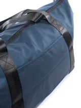 Bolso deportivo Umbro de color azul oscuro, con diseño minimalista y logo de la marca estampado en el frente. Cuenta con correas de mano resistentes y correa ajustable para el hombro.
