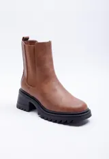 Bota de caña media color marrón con pieza elastizada en los laterales, detalle metálico atrás y plataforma de 6cm de alto.