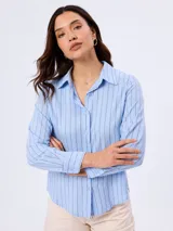 Camisa celeste de manga larga con diseño de rayas verticales negras, cuello camisero y cierre frontal de botones.