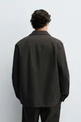 Sobrecamisa de corte relajado confeccionada en tejido mezcla de algodón y lyocell. Presenta cuello solapa, cierre frontal con botones, manga larga con puños abotonados y bolsillos laterales de vivo.