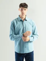 Camisa de manga larga color gris oscuro, confeccionada en algodón, con cuello clásico, cierre frontal con botones, bolsillo de parche en el pecho y corte clásico.