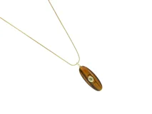 Collar de cadena fina de acero con baño de oro y dije alargado de piedra natural ojo de tigre con una pequeña circonia incrustada en el centro.