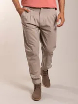 Pantalón bombacha color beige, de sarga, con pinzas en la cintura y corte tapered.