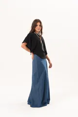 Blusa de silueta relajada y caída fluida, color negro, con escote redondo y mangas amplias.
