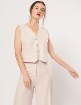 Pantalón negro de lino, tiro alto, corte palazo, con elástico en la pretina trasera, cierre delantero y broche interno. Tiene bolsillos laterales, dobladillo invisible y tajos a los costados.