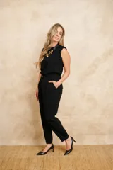 Pantalón tipo babucha de color negro, con pinzas en la parte delantera y bolsillos con tapa en la parte trasera.