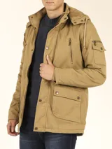 Campera de abrigo estilo parka, color verde militar, con capucha desmontable, cierre frontal con botones y múltiples bolsillos funcionales en pecho, cintura y manga.