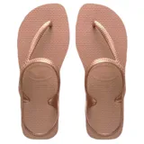 Sandalias tipo ojota Havaianas modelo Flash Urban, con base de goma color rosado y tiras finas metálicas en color oro rosa que rodean el talón.