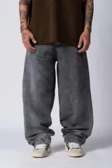Jean de corte baggy con diseño amplio y holgado, confeccionado en denim con efecto de lavado gastado en tono gris oscuro.