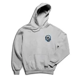 Canguro gris con capucha y bolsillo frontal tipo canguro. Presenta un parche bordado en el pecho con diseño de calavera en colores blanco, negro y azul, y una etiqueta pequeña en el ruedo inferior.