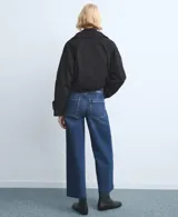 Jeans de corte recto y tiro alto, con diseño de pierna ancha y terminación deshilachada en el ruedo. Presenta un lavado azul clásico con costuras marcadas.