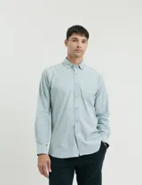 Camisa de tejido Oxford con cuello button-down, manga larga y bolsillo frontal. Presenta botones al tono y un corte clásico.