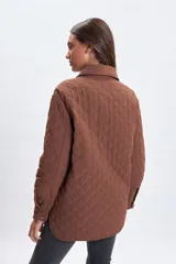 Sobrecamisa de diseño capitoneado en color marrón, con cuello clásico, cierre frontal mediante botones a presión y bolsillos frontales con solapa.