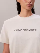 Remera de algodón blanco melange de corte clásico, con cuello redondo, manga corta y el logo de Calvin Klein Jeans estampado en el pecho en color negro.