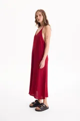 Vestido largo negro de corte holgado, con escote en V y tirantes finos tipo halter.