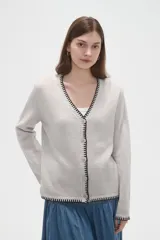 Cardigan de viscosa color marrón, con cuello en V, cierre frontal con botones y detalle de costura decorativa en contraste a lo largo de los bordes.