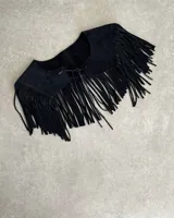 Pechera de cuero vacuno en color negro, diseñada con flecos largos y cierre frontal mediante lazo. Es un accesorio versátil tipo cuello para complementar prendas básicas.